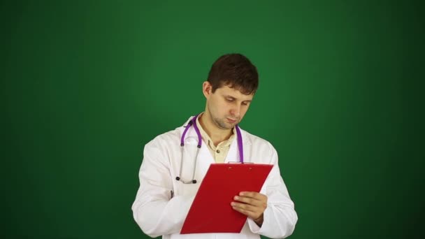 El doctor escribe con una pluma. Doctor sobre un fondo verde . — Vídeos de Stock