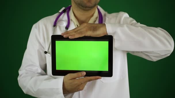 Médico sosteniendo una tableta con una pantalla verde . — Vídeo de stock