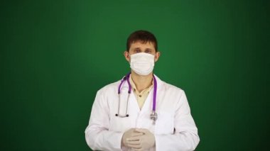 Yaşasın doktor tıbbi maske içinde ortaya çıktı. Başparmak yeşil zemin üzerine Doktor ortaya.