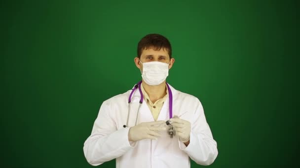 Ένα γιατρό με σύριγγα σε μια ιατρική μάσκα. — Αρχείο Βίντεο