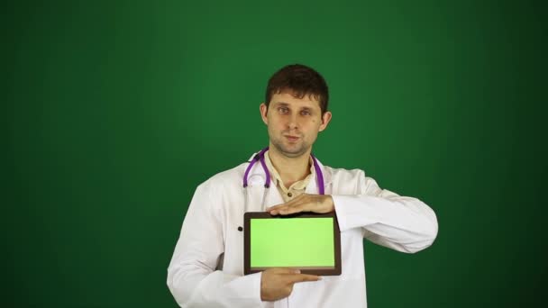 Doktor je drží tabletový počítač s zeleným plátnem. Doktor na zeleném pozadí se tabletový počítač. — Stock video