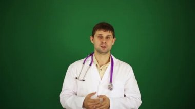 Doktor kameraya diyor. Erkek bir doktor konuşuyor. Doktor yeşil bir arka plan üzerinde.