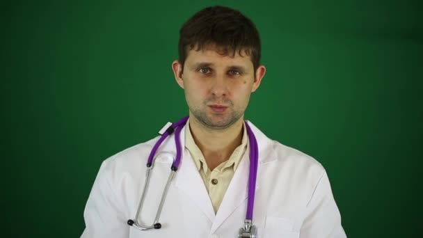 Vážnou doktor na zeleném pozadí. Doktor v bílém plášti, terapeut, lékař. — Stock video