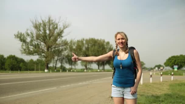 La fille arrête la voiture sur la route. Jeune femme auto-stop le long d'une route . — Video