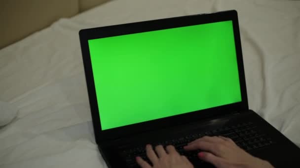 Φορητό υπολογιστή με μια πράσινη οθόνη. Ένας άνδρας εργάζεται πίσω από ένα φορητό υπολογιστή με μια πράσινη οθόνη. — Αρχείο Βίντεο