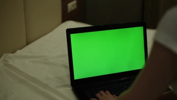 Een vrouw is het typen op een laptop met een groen scherm. Laptop met een groen scherm. — Stockvideo