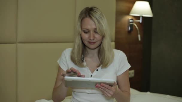 Kvinna med en surfplatta. En tjej är att skriva på en tablet-dator hemma. — Stockvideo