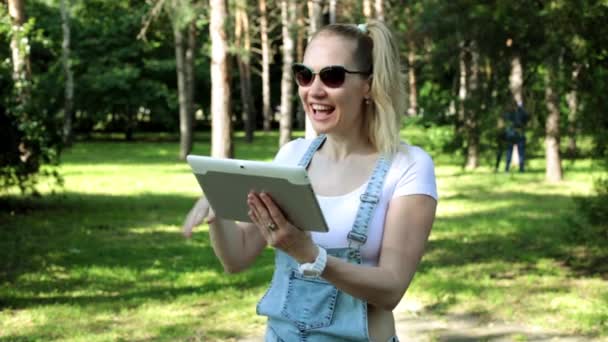 Una mujer habla por Skype usando una tableta. Las mujeres hablan de comunicación por vídeo a través de una tableta . — Vídeos de Stock