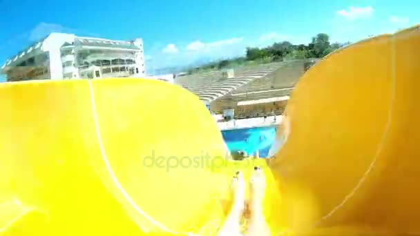 Parque acuático, toboganes acuáticos, atracción acuática. Una mujer está rodando en un tobogán de agua . — Vídeos de Stock