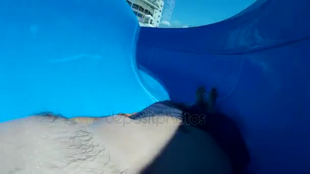 Riposo attivo, parco acquatico, scivoli d'acqua, action camera. Un uomo scivola su uno scivolo d'acqua . — Video Stock