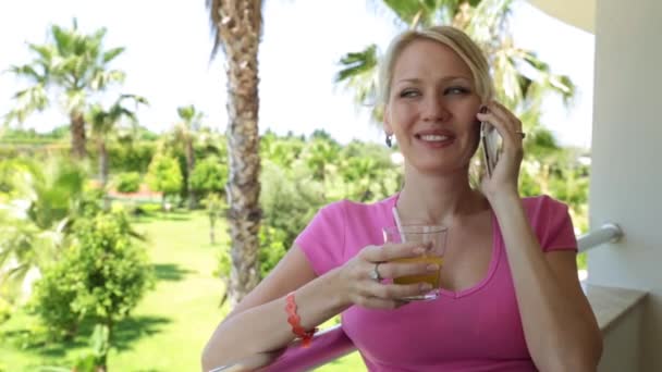 Die Frau telefoniert im Hotel. Eine Frau telefoniert vor Palmenkulissen. Urlaub, Sommer, Ferienort. — Stockvideo