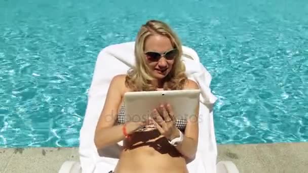 Mädchen mit einem Tablet am Pool. Frau mit Tablet-Computer im Hintergrund des Pools. — Stockvideo