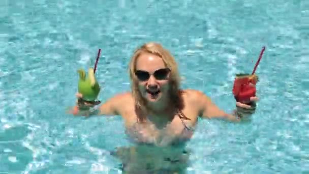 Bella donna con un cocktail in piscina. Ragazza in costume da bagno in piscina. Una donna balla e beve un cocktail . — Video Stock