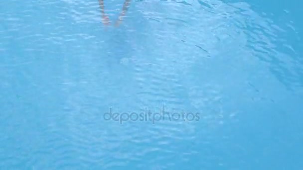 Eine junge Frau schwimmt im Pool. ein schönes Mädchen schwimmt unter dem Wasser im Pool. — Stockvideo