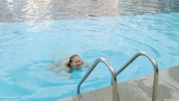 Menina sexy em biquíni sai da piscina. Uma mulher bonita nas escadas da piscina. Jovem de fato de banho . — Vídeo de Stock