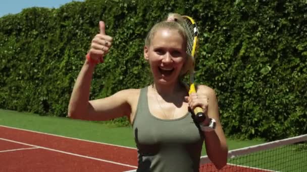 Žena s tenisovou raketu ukazuje palec. Pozitivní atraktivní tenista. — Stock video