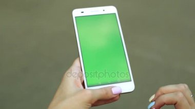 Kadın el smartphone dokunmadan. Yeşil perde göstermek. Yeşil bir ekran ile telefon.