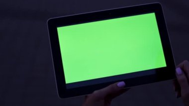 İçeriğiniz için yeşil bir ekran olan tablet bilgisayar. Yeşil bir ekran ve karanlık bir arka plan ile bir tablet.