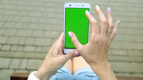 En smartphone med en grön skärm. En man håller en telefon med en grön skärm. — Stockvideo