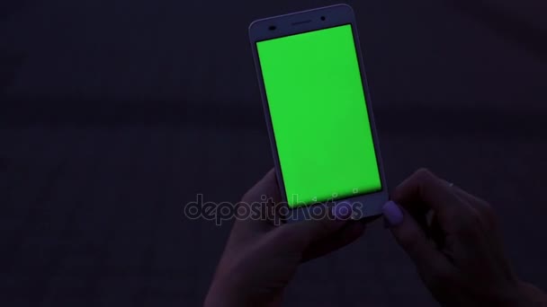 Woman hands touching smartphone. Phone with a green screen. Green screen display. — Stock Video