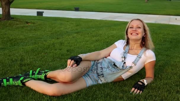 Jeune femme sur patins à roulettes écoutant de la musique dans le parc . — Video