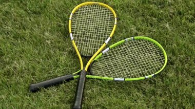 Raketle ve badminton raket. Yeşil çimenlerin üzerinde raketle ve badminton raket.