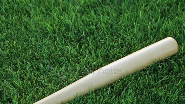 Um taco de basebol na relva, de perto. Beisebol, desporto, treino . — Vídeo de Stock
