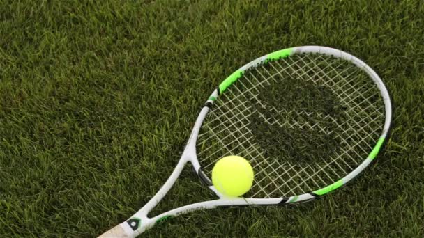 Теннисная ракетка и мяч на траве — стоковое видео