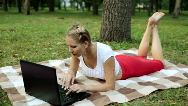Attraktiva flicka med laptop på gräset. Affärskvinna i park med laptop. — Stockvideo