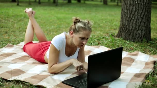 Деловая женщина в парке с ноутбуком. Привлекательная девушка с ноутбуком на траве . — стоковое видео