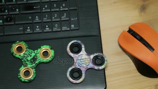 Wirtschaft und Unterhaltung. zwei Spinner-Spielzeuge und ein Laptop. — Stockvideo