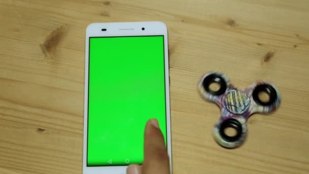 Une personne utilise un smartphone avec un écran vert sur le bureau . — Video