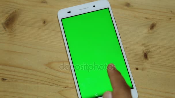 Egy ember egy smartphone használ egy zöld képernyő. — Stock videók