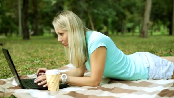 Девушка с ноутбуком на природе. Молодая женщина с ноутбуком в парке . — стоковое видео