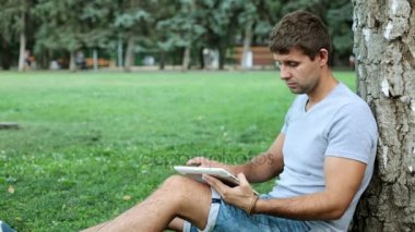 Bir tablet bilgisayar parkta bir erkekle.