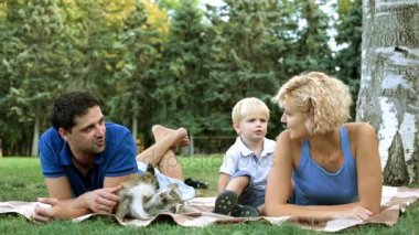 Parkta bir ekose üzerinde bir çocukla mutlu aile.