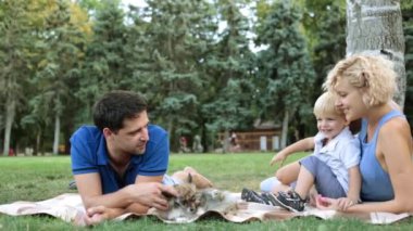 Bir ekose parkta oturan bir çocuk ile mutlu bir aile. Parkta bir çocuk ile anne.