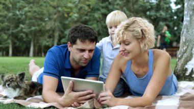 Mutlu bir aile ve dijital teknoloji. Bir çocuk ve bir tablet bilgisayar Park ile aile.