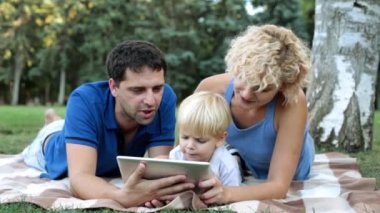 Anne, baba ve oğlu ile bir tablet niteliğine. Bir çocuk ve bir tablet bilgisayar Park ile aile.