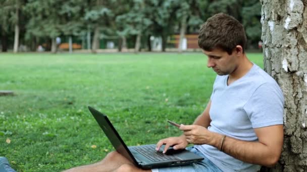 Homme avec carte de crédit et ordinateur portable. Un homme avec un ordinateur portable utilise une carte de crédit bancaire . — Video