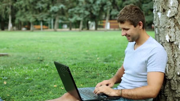 ノート パソコンを持つ男は、成功を楽しんでいます。公園でラップトップを持つ男. — ストック動画