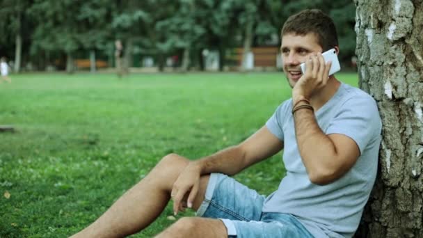 Bir adam parkta telefonda konuşuyor — Stok video