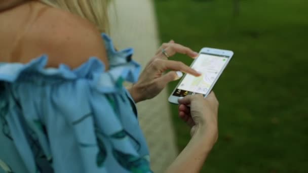 Smartphone de pantalla con un mapa de la ciudad. Una persona sostiene un teléfono inteligente con una interfaz de navegador . — Vídeos de Stock