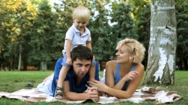 Parkta oynayan çocuk ile mutlu aile.