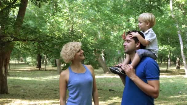 Jonge gelukkig gezin met baby in park. — Stockvideo