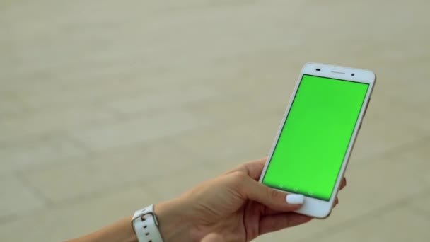 Uno smartphone con schermo verde. Un uomo tiene in mano uno smartphone con uno schermo verde . — Video Stock