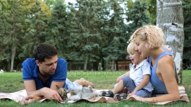 Baba, anne ve bebek bir ekose bir parkın içinde. Bir piknik bir çocuk ile aile.