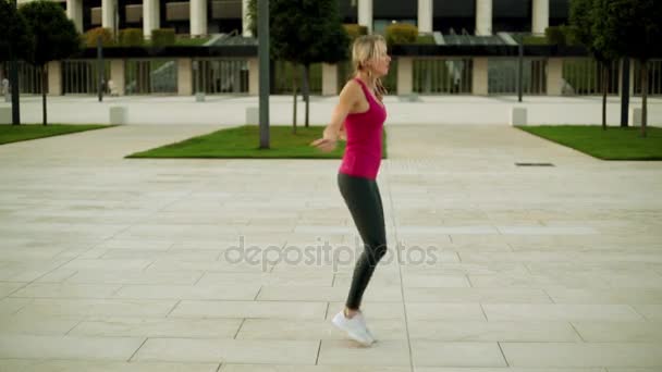 Ung kvinna hoppa rep i parken. Flickan är engagerad i fitness. — Stockvideo
