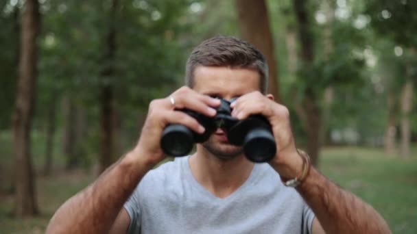 A young man looks through binoculars. — Stock Video