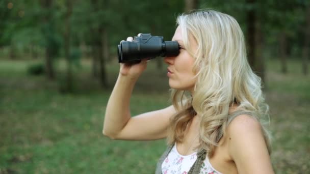 Bella donna guarda attraverso il binocolo. La ragazza guarda attraverso il binocolo con un'espressione dispiaciuta . — Video Stock